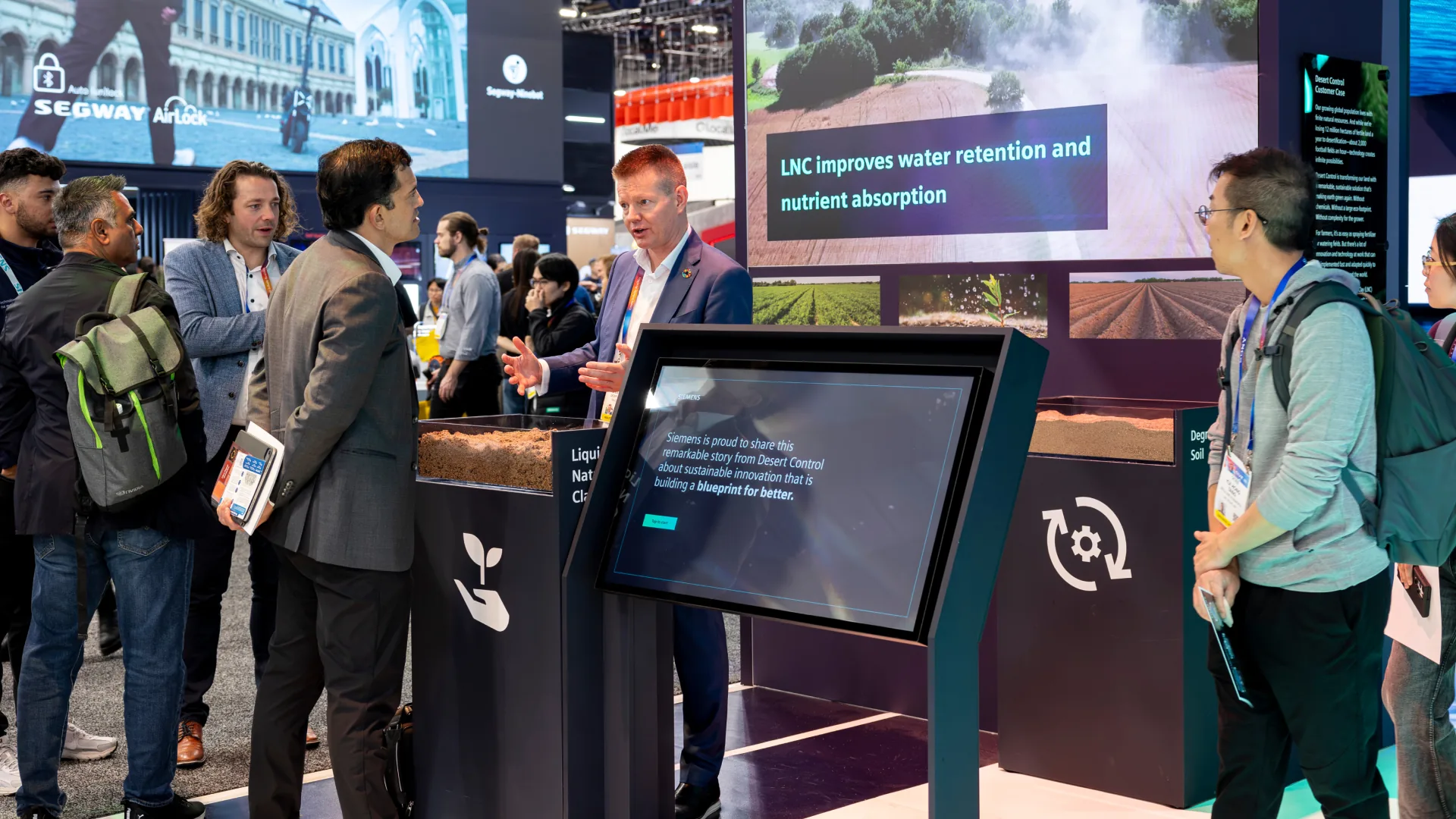 Visitors and hosts talk around a kiosk at the Desert Control story zone