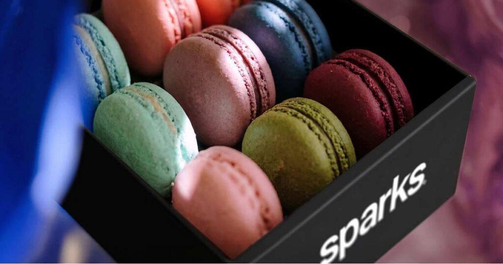 Branded experiential hospitality at a Sparks-produced healthcare exhibit — custom macarons and elevated food design turning refreshment into an extension of brand storytelling.