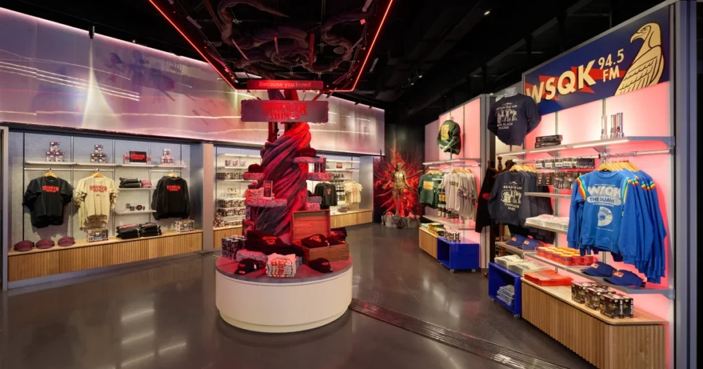 Stranger Things retail anchor at Netflix House Dallas featuring a twisted Vecna tree column, overhead title signage, and Hawkins-themed Easter eggs across the displays.