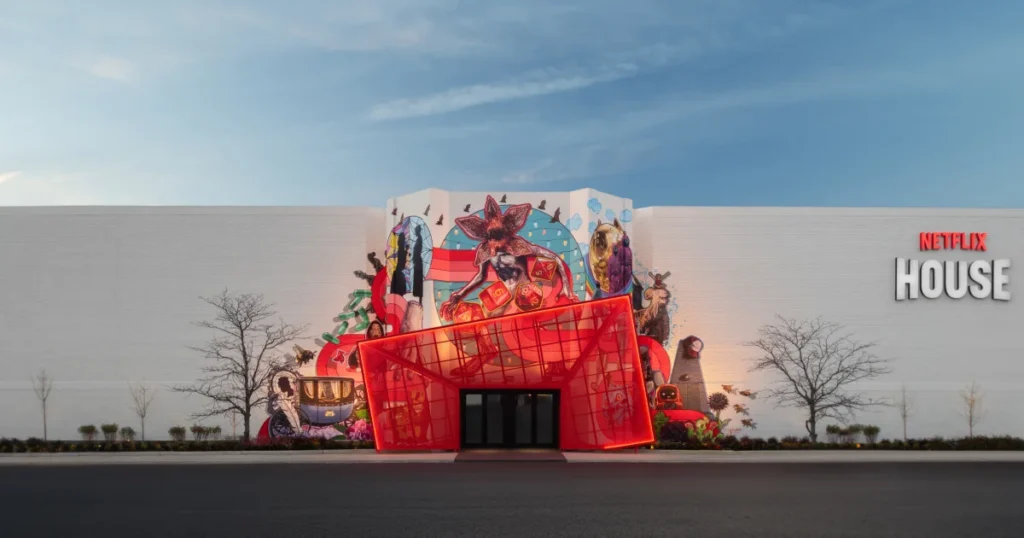 Netflix House Philadelphia exterior at twilight showing the title-world mural wall and the angular red entrance portal at King of Prussia.