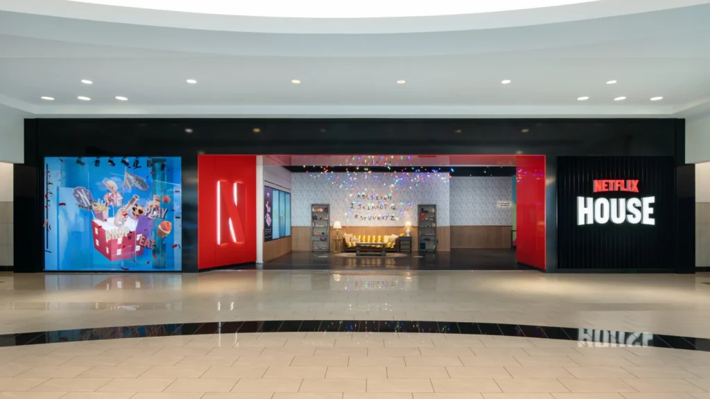 Netflix House Philadelphia mall storefront featuring Stranger Things Alphabet Wall visible through the entrance, with a "Shop N Play" cartoon window display and the Netflix House wordmark.