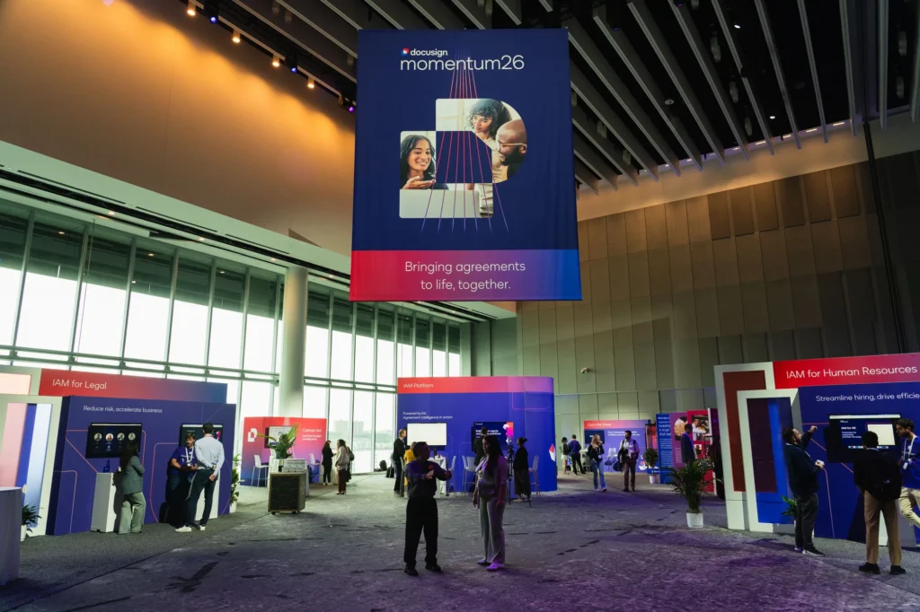 The Agreement Expo at Docusign Momentum 2026, with a "Bringing agreements to life, together" banner over the IAM demonstration zones.