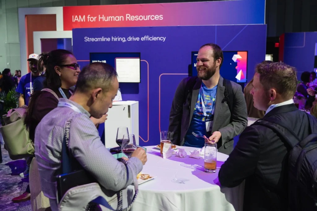 Attendees networking at a high-top table in the IAM for Human Resources zone of the Docusign Momentum 2026 Agreement Expo.