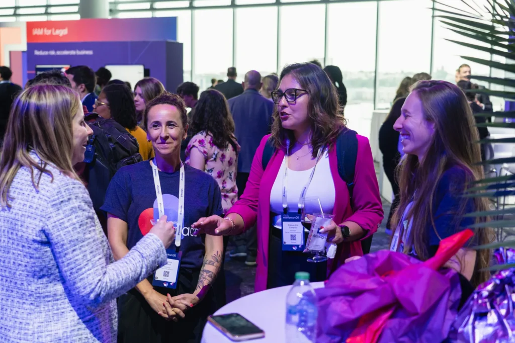 Attendees networking on the Docusign Momentum 2026 Agreement Expo floor, with Manhattan views at the Javits Center.