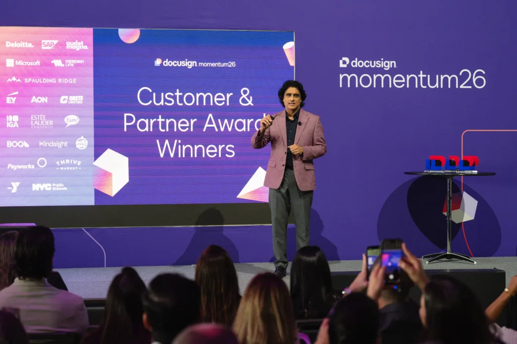 Customer and partner award winners recognized on the Docusign Momentum 2026 main stage, with partner logos on the LED wall and an engaged audience.