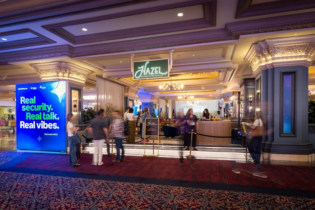 Sparks-designed ServiceNow Hazel Lounge takeover at Black Hat 2026 with a "Real security. Real talk. Real vibes." branded lightbox at the entrance to Hazel Coffee & Cocktails inside Mandalay Bay in Las Vegas.