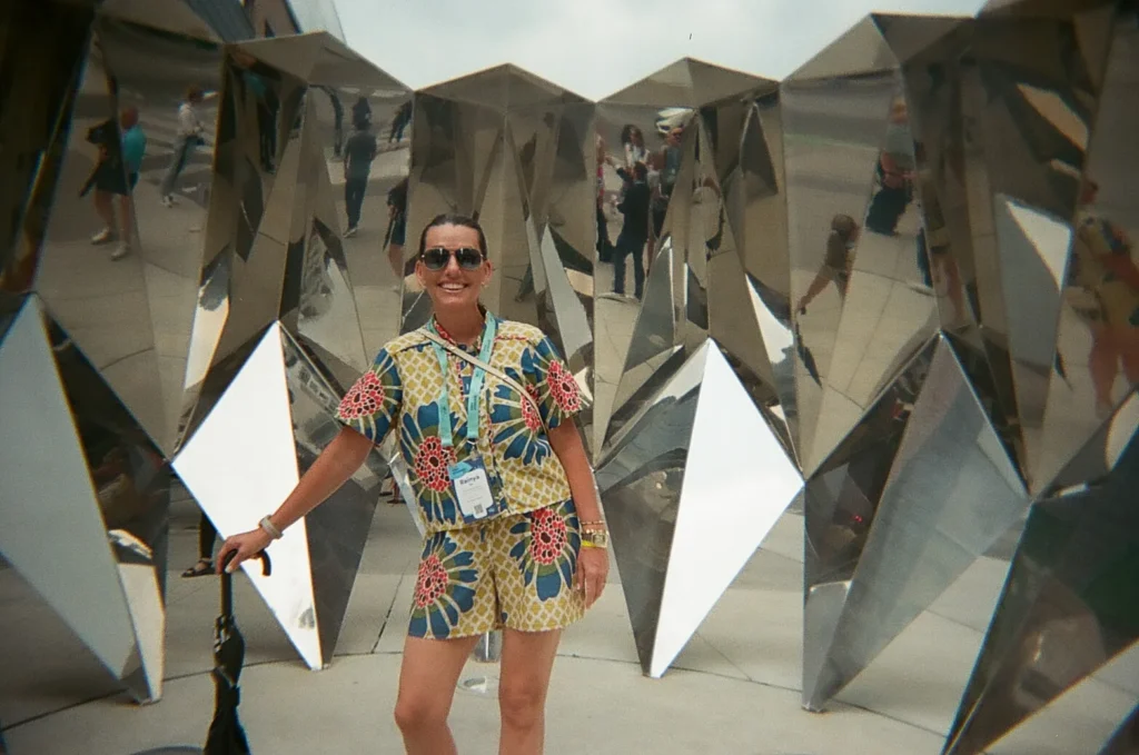 Sparks-hosted CEMA Summit 2026 disposable-camera photo — a CEMA Summit attendee poses inside a mirrored geometric sculpture during the Sparks-led Graffiti Alley walking tour in Toronto.