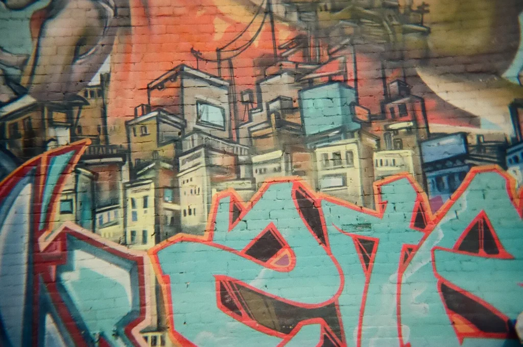 Sparks-hosted CEMA Summit 2026 disposable-camera photo — a Rio-style favela cityscape mural in Toronto's Graffiti Alley, captured by a CEMA Summit attendee on the Sparks-led walking tour.