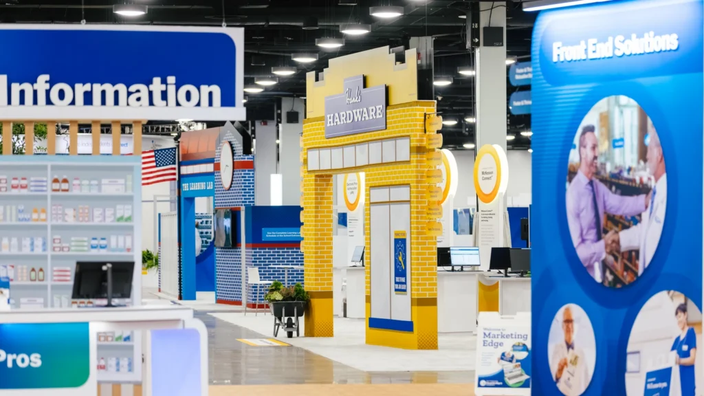 The Sparks-designed Front End Solutions zone with retail-style shelving on the Main Street USA-themed McKesson ideaShare 2025 tradeshow floor at the Gaylord Opryland Resort & Convention Center in Nashville.