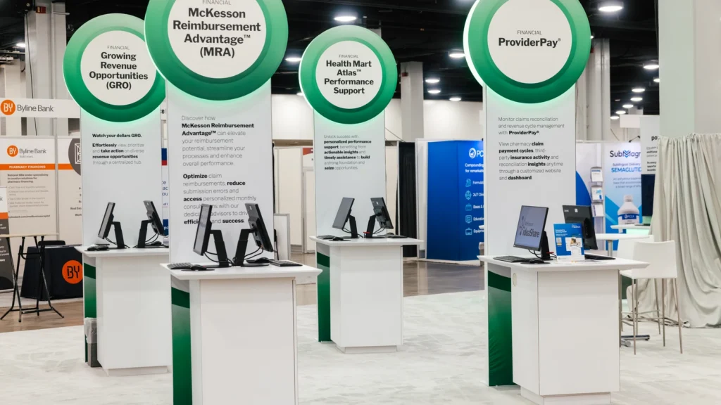 The Sparks-designed McKesson Reimbursement Advantage (MRA) product zone — with ProviderPay and Growing Revenue Opportunities signage — on the Main Street USA-themed McKesson ideaShare 2025 tradeshow floor at the Gaylord Opryland Resort & Convention Center in Nashville.