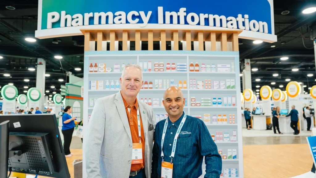 A McKesson representative and a pharmacist meet inside the Sparks-designed Pharmacy Information zone on the Main Street USA-themed McKesson ideaShare 2025 tradeshow floor at the Gaylord Opryland Resort & Convention Center in Nashville.