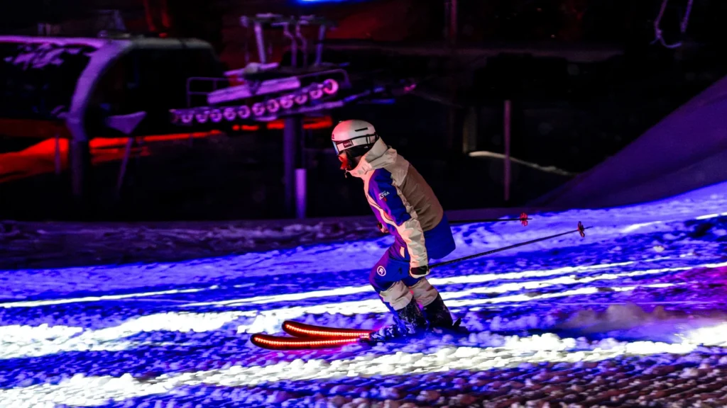 Return of night skiing at Sparks-produced Michelob ULTRA Summit, Canyons Village at Park City — skier in Michelob ULTRA gear descending the summit run under new lighting infrastructure installed for one night only at 8,000 feet.