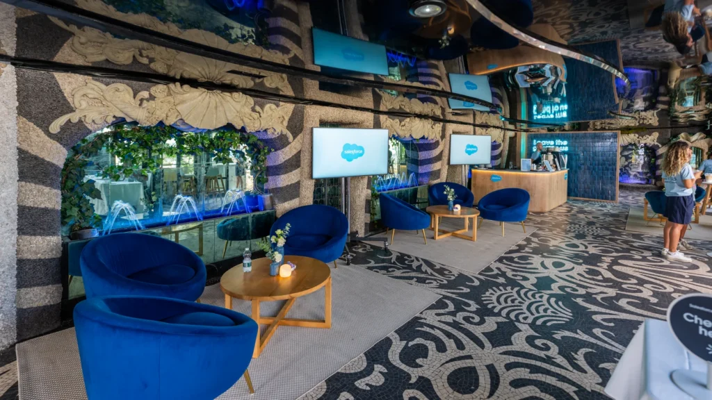 Baroque blue velvet lounge chairs, water fountain wall and Salesforce screens inside the Sparks-designed grotto-style lounge at Salesforce Beach, Cannes Lions 2026.