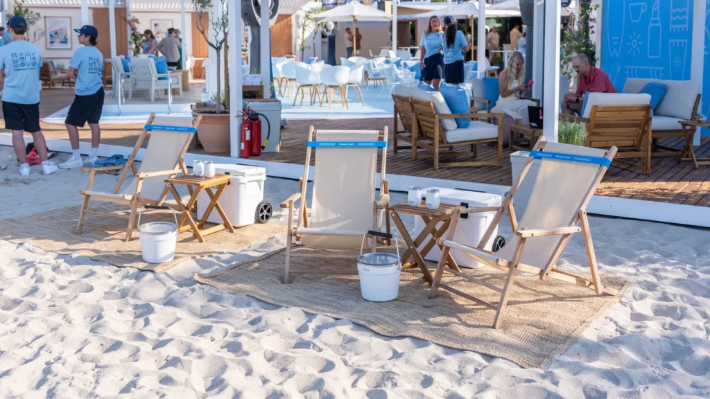 Reserved beach chairs with white buckets on a woven sand rug facing the Mediterranean at the Sparks-designed Salesforce Beach experience at Cannes Lions 2026.