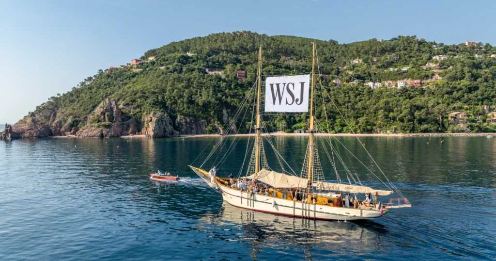 Aerial view of a classic Riva runabout drawing alongside the O'Remington heritage schooner during the staged "paparazzi" moment mid-cruise at the Sparks-produced Riviera at Dawn for The Wall Street Journal at Cannes Lions 2026.