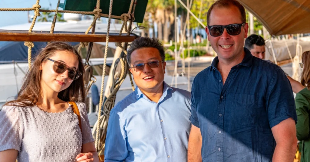Three VIP guests posing together on the deck of the O'Remington heritage schooner at the Sparks-produced Riviera at Dawn breakfast cruise for The Wall Street Journal at Cannes Lions 2026.