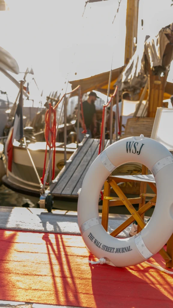 Wall Street Journal-branded life ring on the red carpet at the O'Remington gangway at Port Canto — a restrained brand detail at the Sparks-produced Riviera at Dawn for The Wall Street Journal at Cannes Lions 2026.