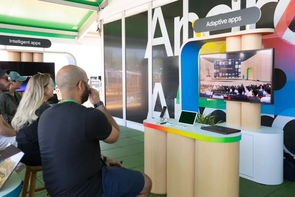 Developers watch an Android adaptive apps demo on a large display