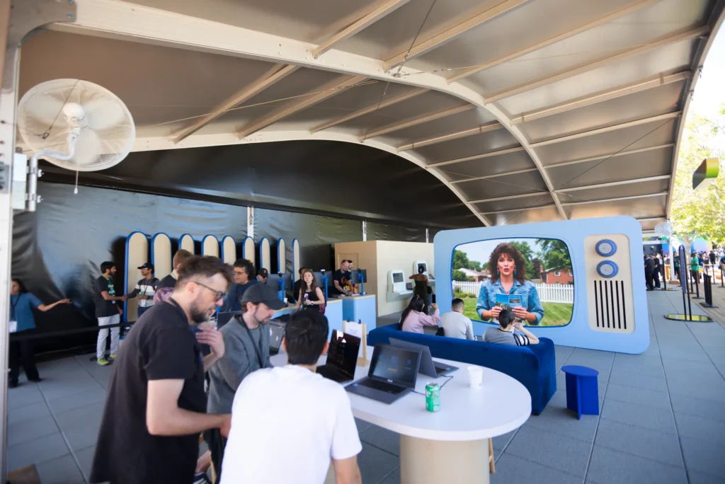 Developers talk through a product demo at a laptop station