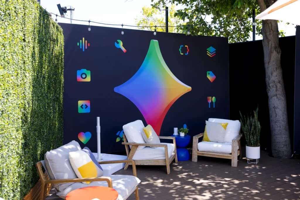 Quiet outdoor lounge seating beside a green hedge wall and colorful spark graphic