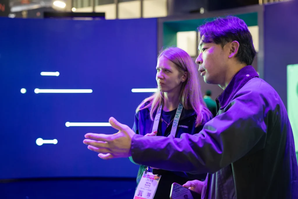 Siemens expert in a one-to-one conversation with a CES 2026 attendee inside the Siemens exhibit.