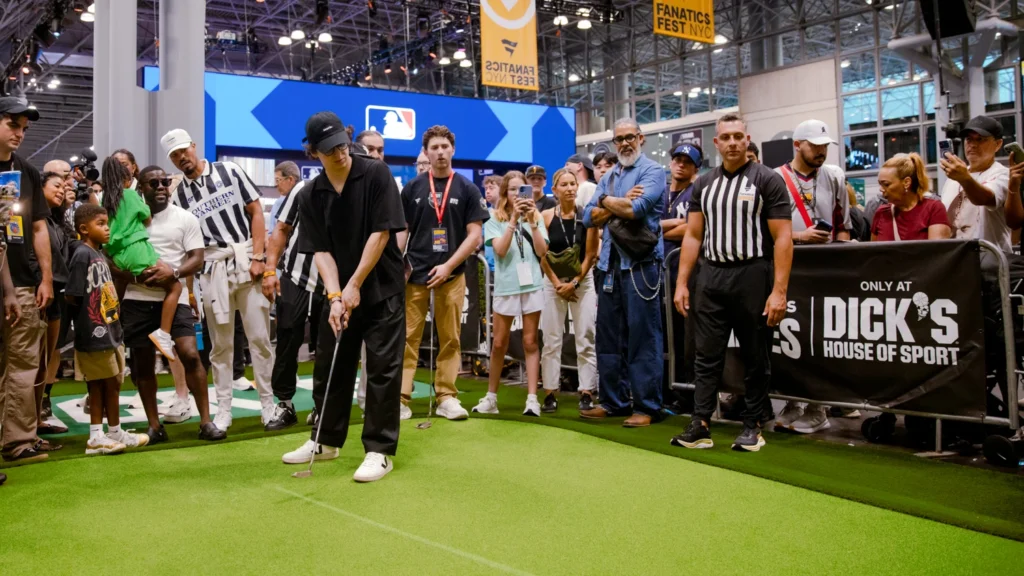 A fan takes the winning putt at the DICK'S Putting Challenge inside the Fanatics Games competition zone at the Sparks-built DICK'S Sporting Goods activation at Fanatics Fest 2026 — the PuttView-powered green Sparks integrated so DICK'S could go head-to-head with the NFL, NBA, and MLB as the Fanatics Games' exclusive brand partner.