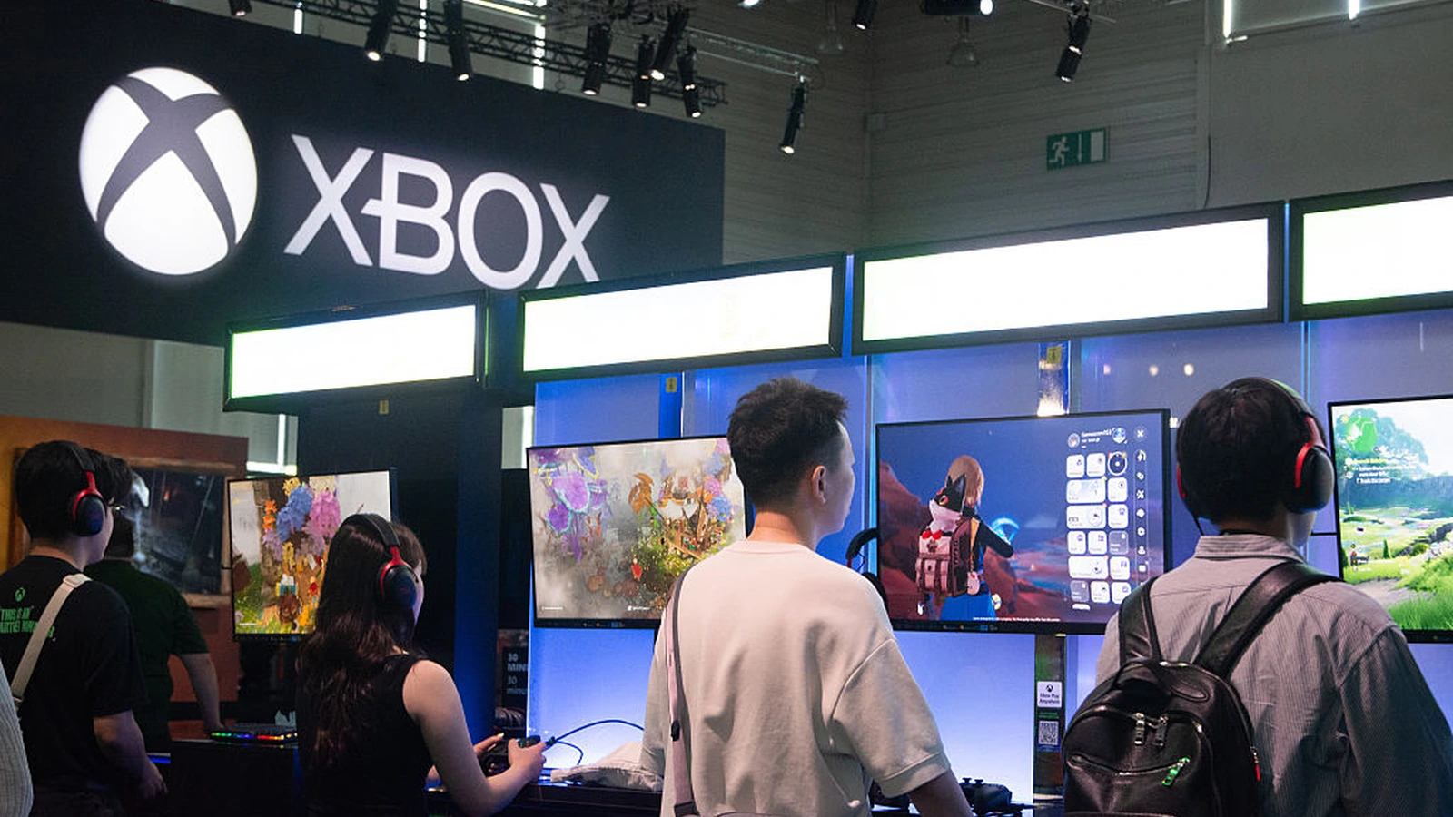 Attendees wearing red headsets play at Xbox gaming stations inside the Xbox booth at Gamescom 2025 in Cologne, Germany — part of the 120 gaming stations Sparks measured for its Earned Engagement Value (EEV) analysis of the Xbox program at Koelnmesse.