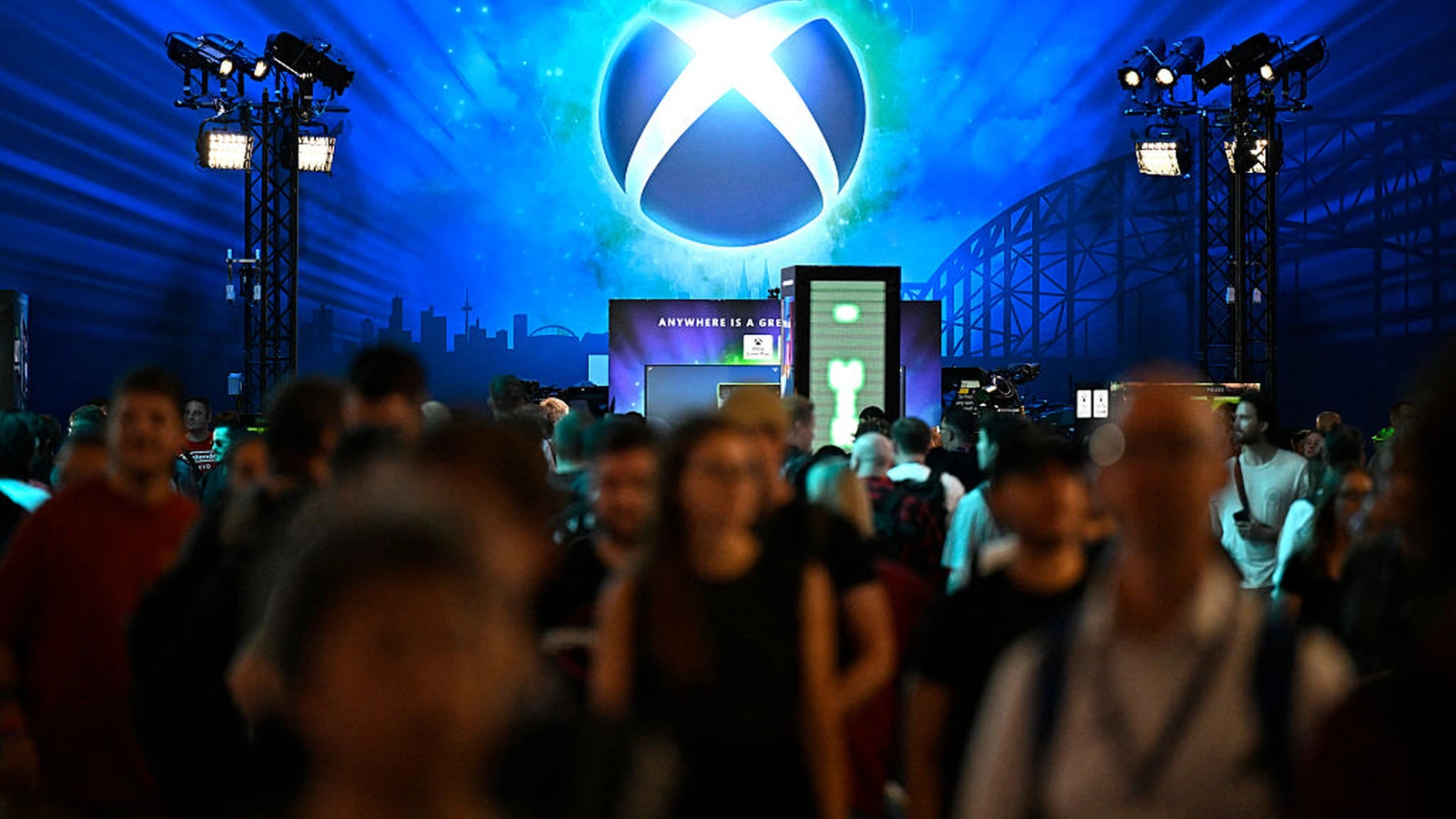 The illuminated Xbox sphere logo above the Xbox booth at Gamescom 2025 in Cologne, Germany — a packed crowd of attendees fills the booth entrance beneath the 'Anywhere Is A Great Place To Play' branding at Koelnmesse. Sparks built the measurement program that quantified this booth's Earned Engagement Value and Earned Event Impression Value.