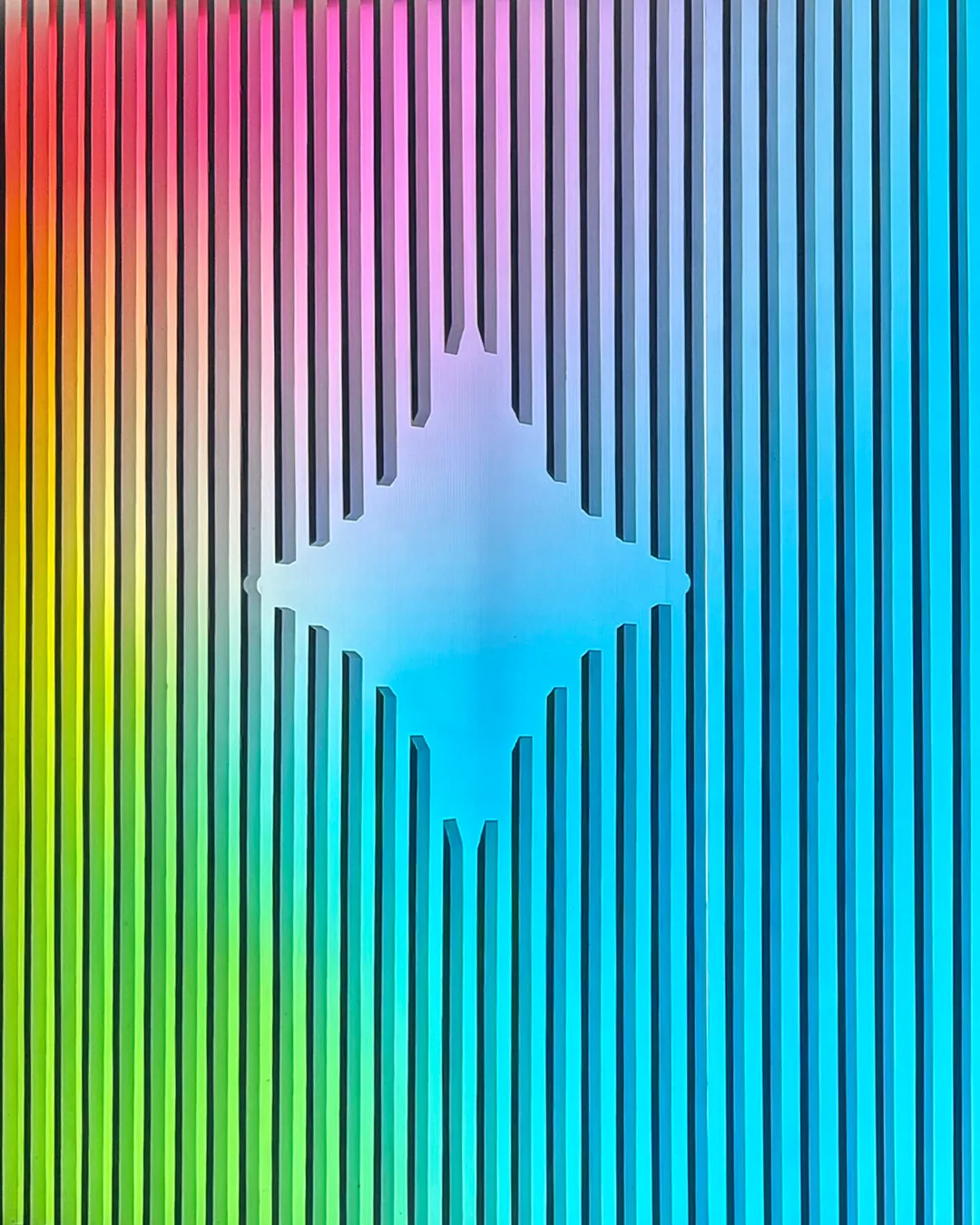 Close-up of color-shifting vertical fins framing a glowing Gemini spark