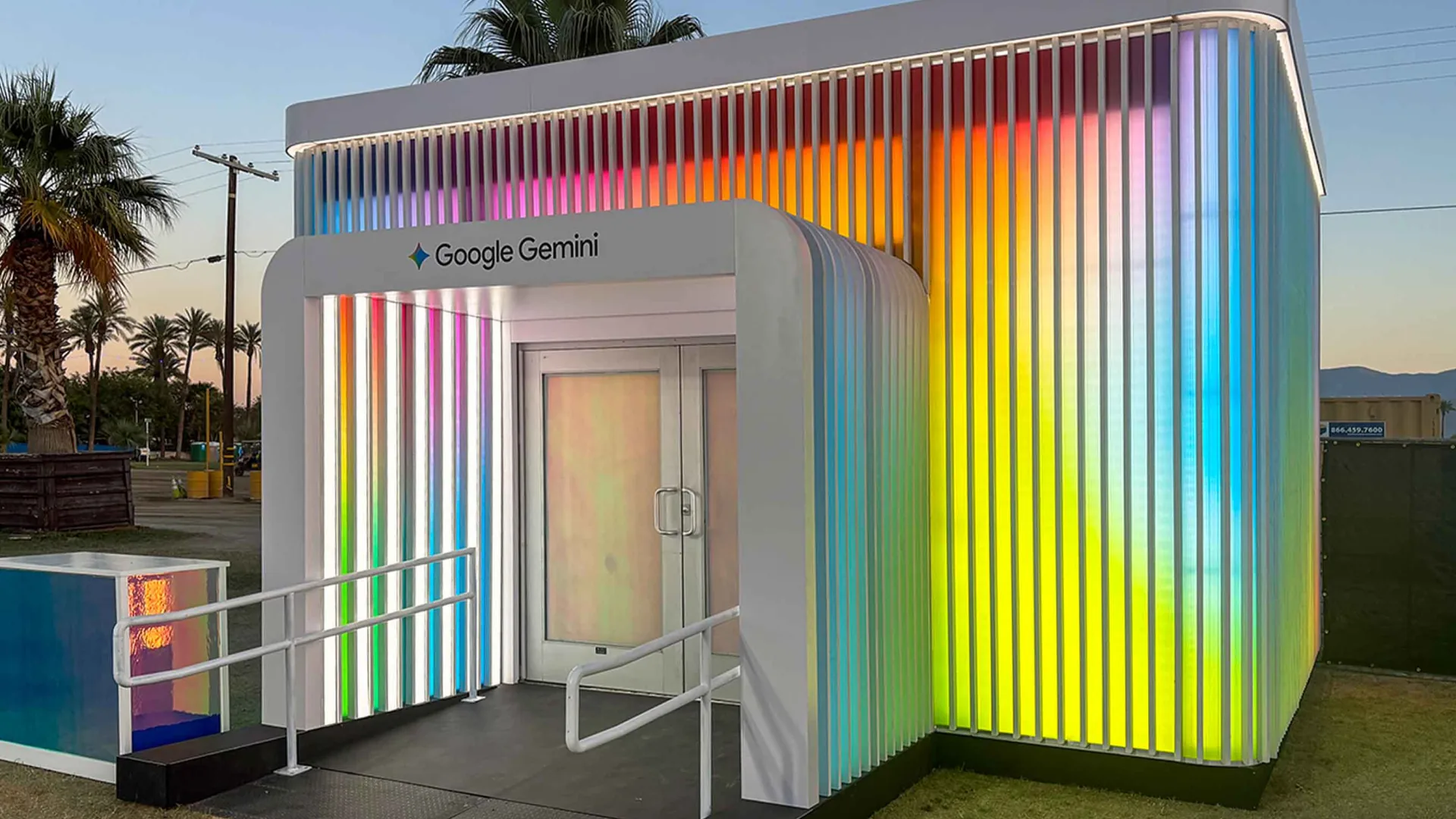 Gemini activation glowing in rainbow gradients at sunset among desert palm trees
