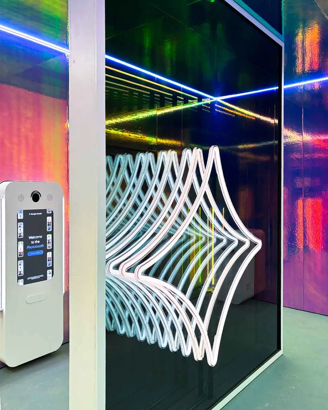 Mirrored interior with neon Gemini spark sculpture beside a white Nano Banana photo kiosk