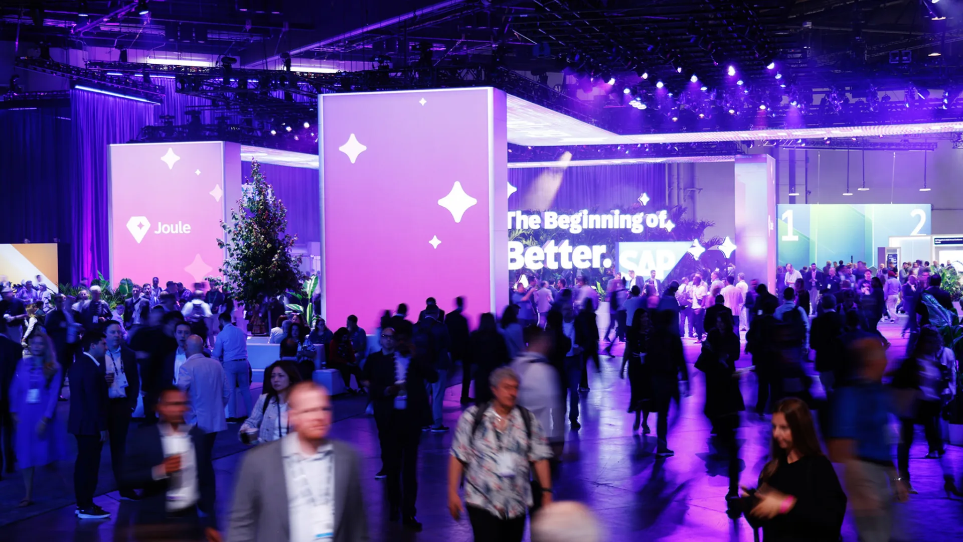 Busy crowd crosses the SAP Sapphire show floor past Joule towers and signage