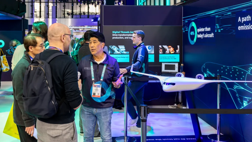 Attendees at CES listen to a host beside the JetZero blended-wing aircraft model
