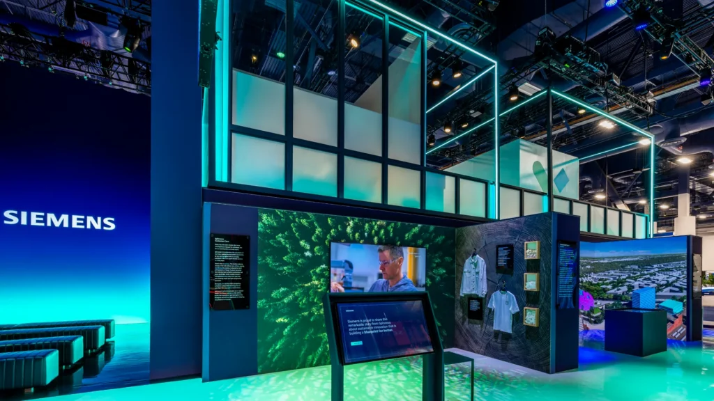 Spinnova story zone with a forest video wall, hanging garments, and an interactive kiosk