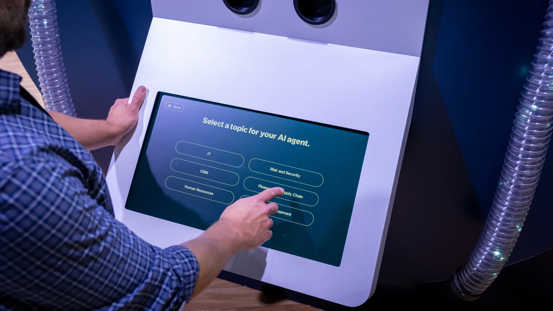 Visitor selects a topic for an AI agent on a touchscreen between LED tubes