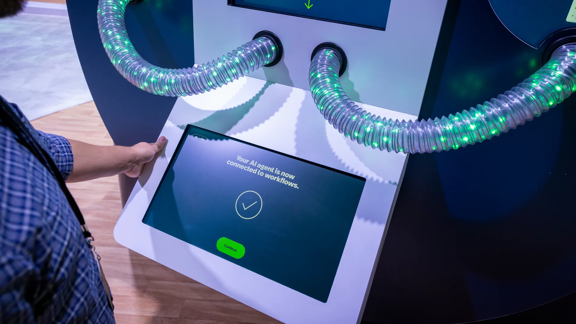 Two lit tubes plug into a Sparks-built kiosk confirming the AI agent is connected