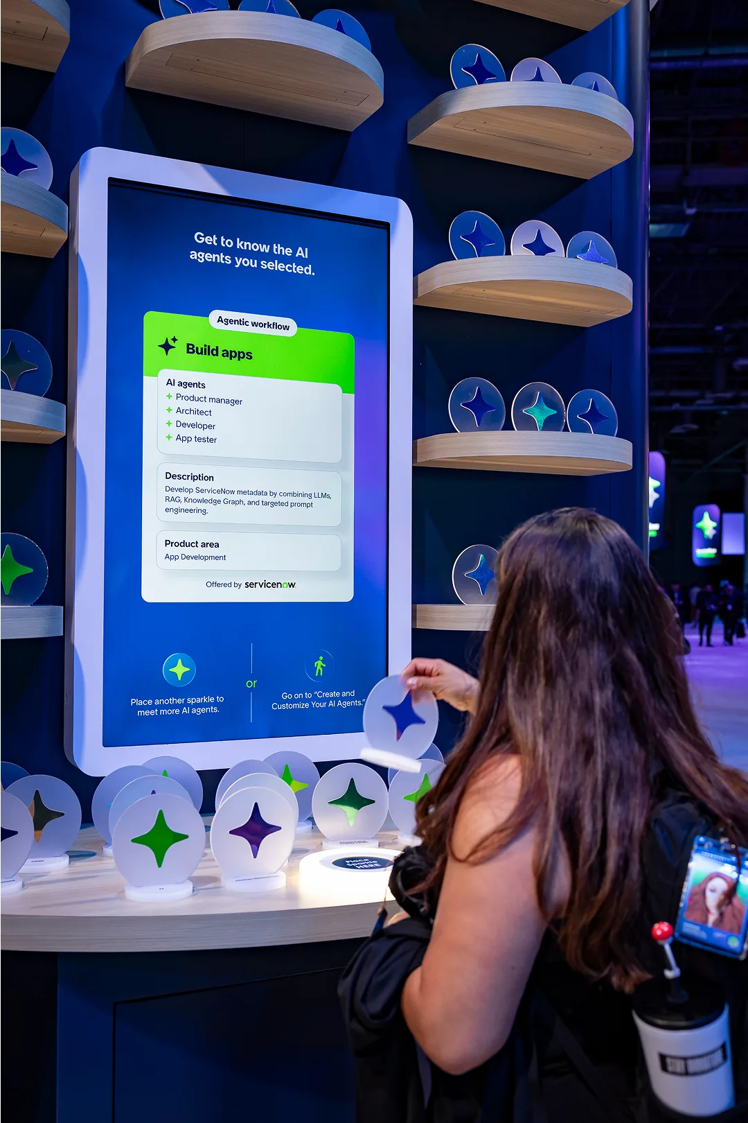 Attendee places a sparkle disc below a screen that reveals her selected AI agents