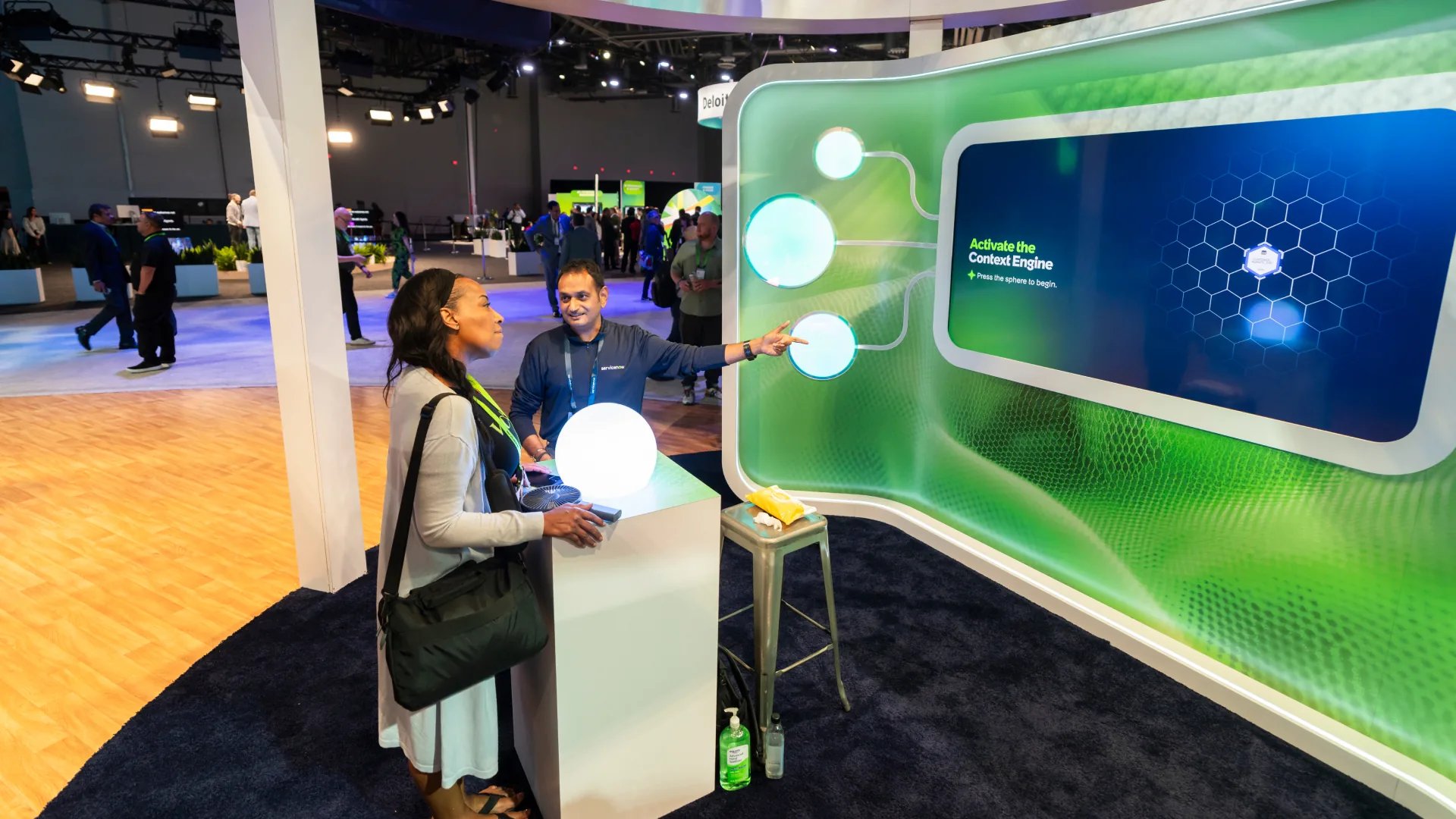 Attendee presses a glowing sphere to start the Context Engine on a curved display