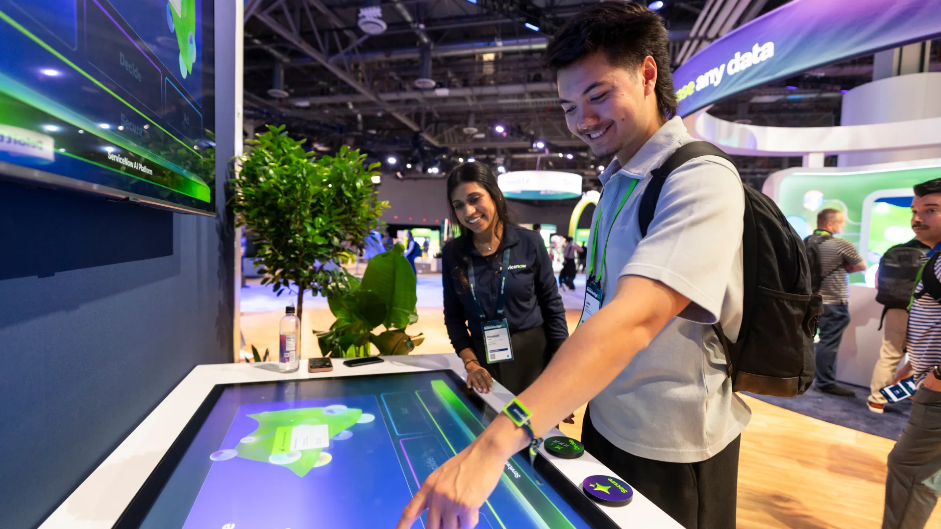 Smiling attendee presses a physical button on an interactive touch table